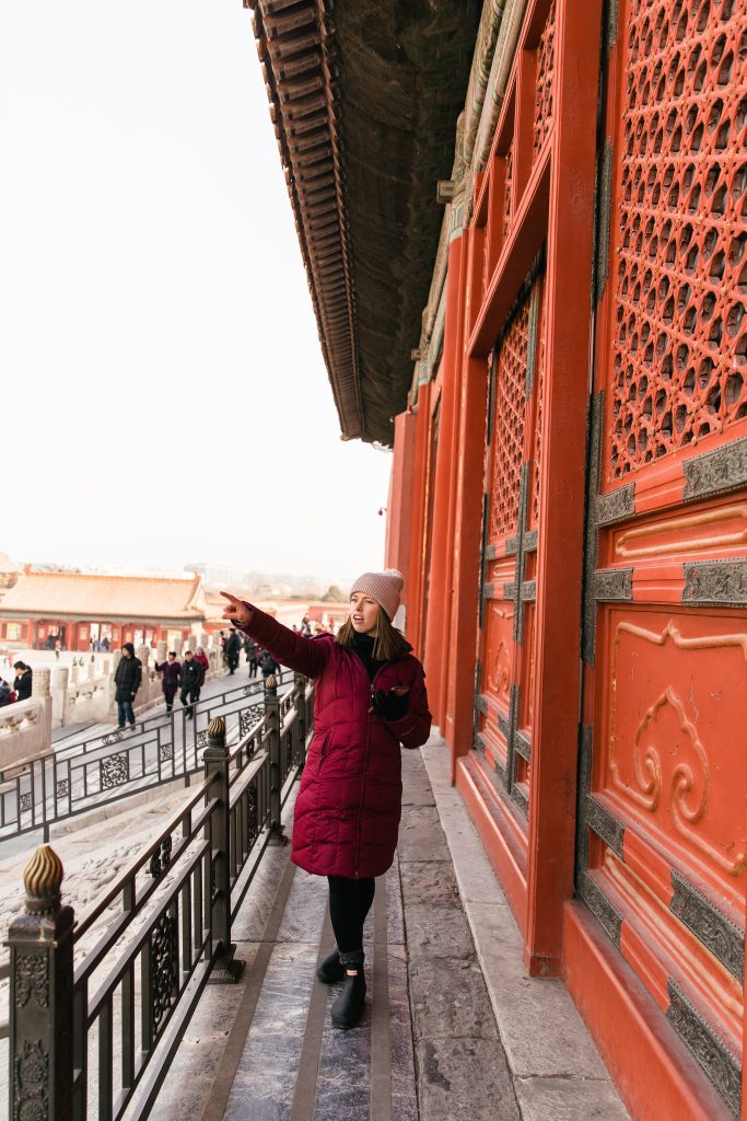 girl pointing at the Forbidden City in Beijing, China
