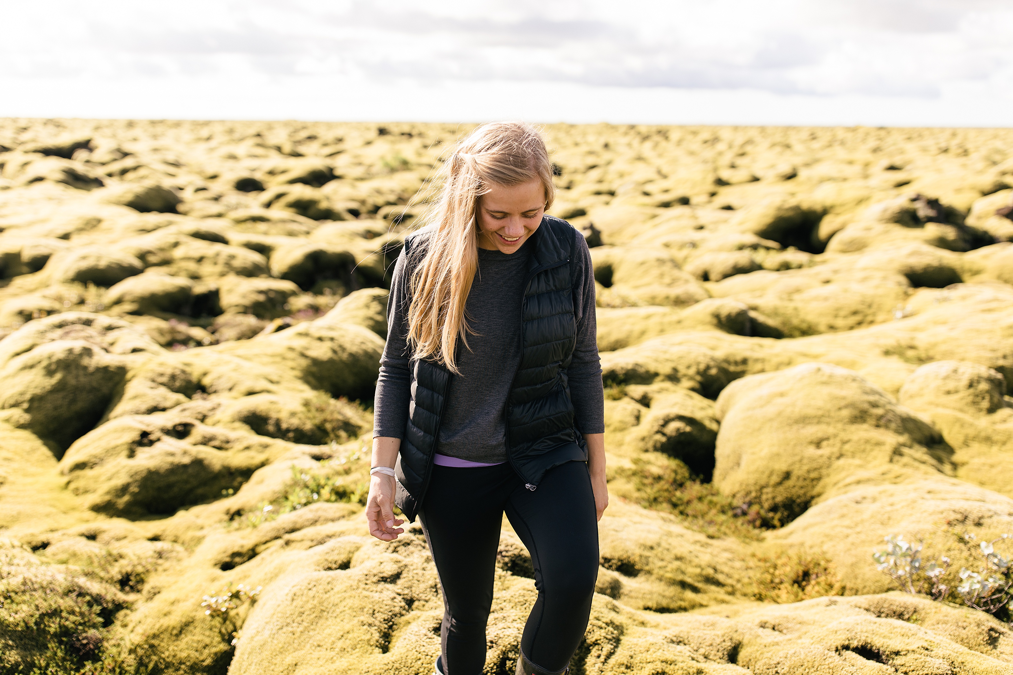 girl walking through Iceland in a black vest