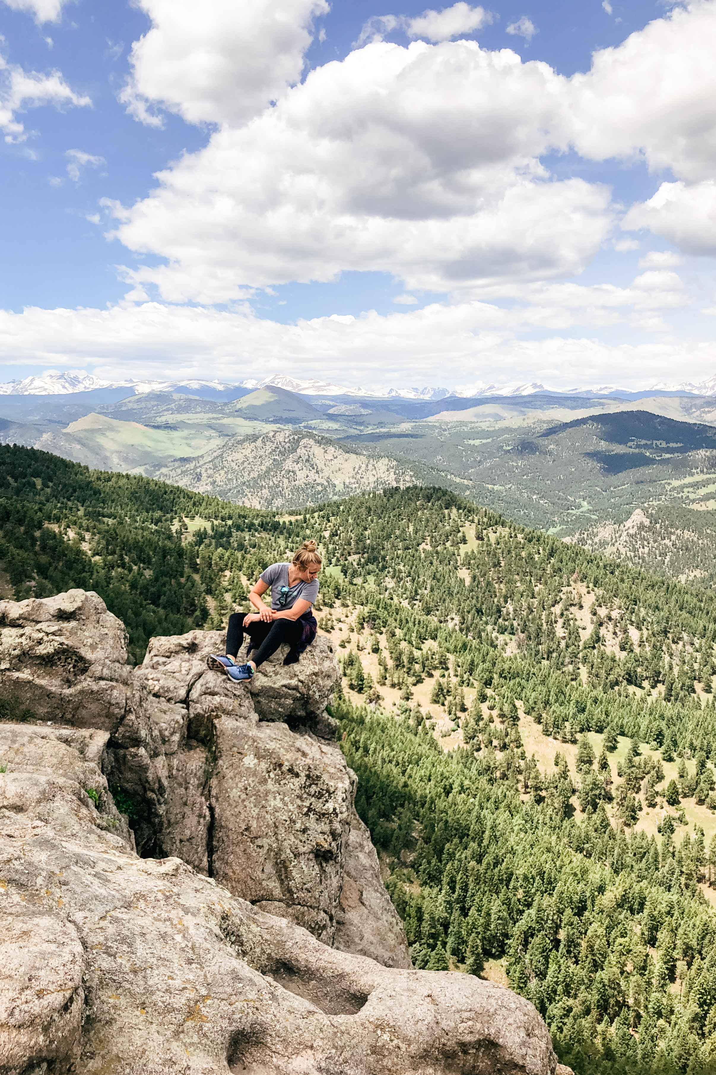 girl sitting on rock in front of Indian Peaks